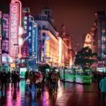 people walking and standing at the streets of the city during night